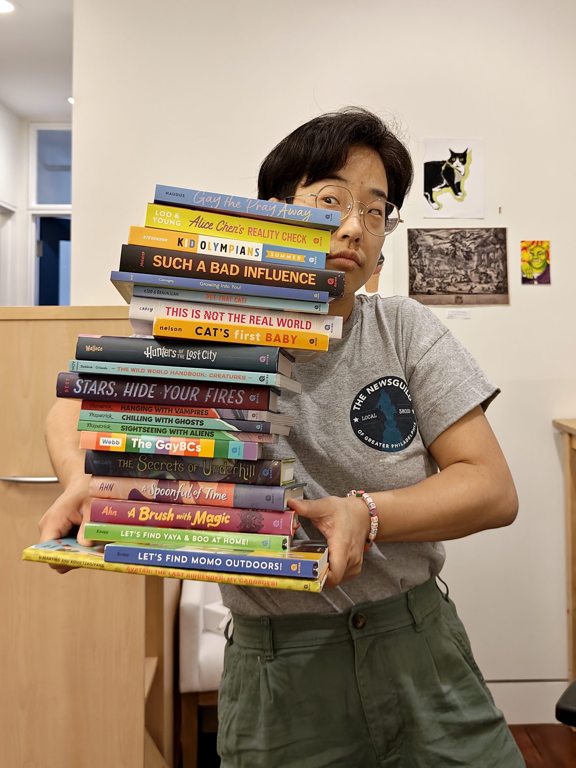 Jessica holding a teetering pile of books